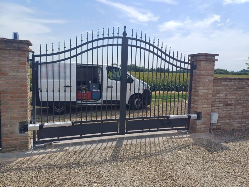 Cancello battente automatico a due ante all’ingresso di una casa di campagna in provincia di Modena